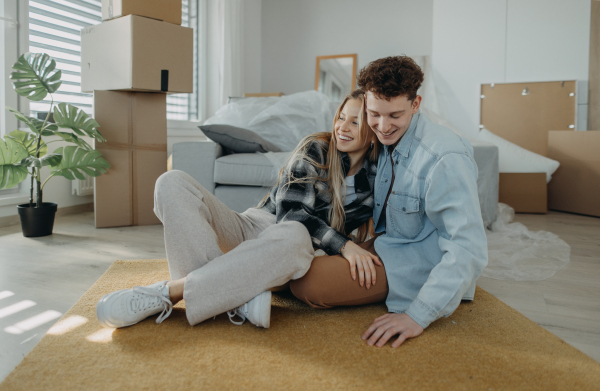 A cheerful young couple in their new apartment. Conception of moving.