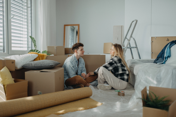 A cheerful young couple in their new apartment. Conception of moving.