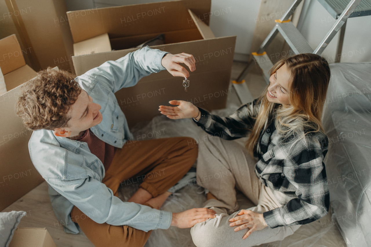 A top view of cheerful young couple in their new apartment. Conception of moving.