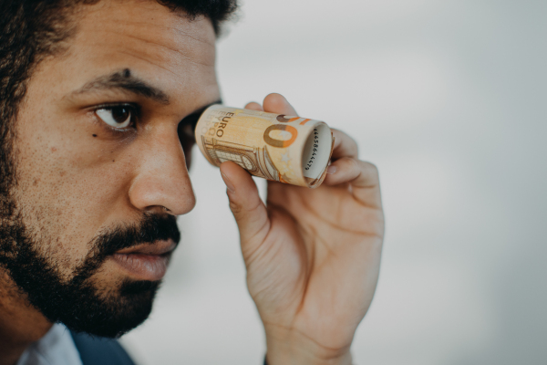 a Depressed businessman man holding banknotes in a tube, inflation concept.