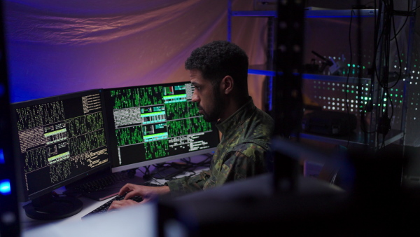 An American hacker in military unifrorm on dark web, cyberwar concept.