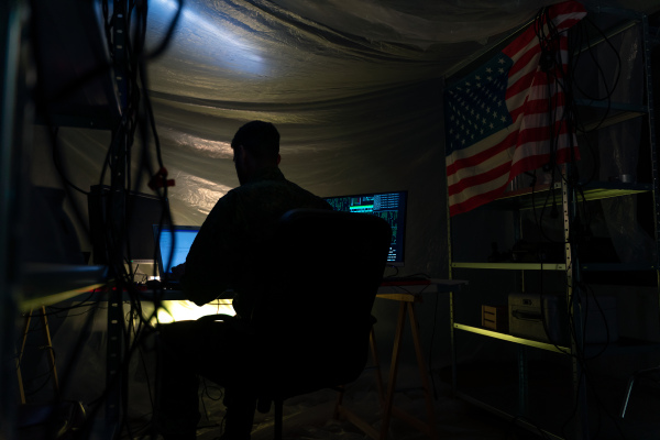 An American hacker in military unifrorm on dark web, cyberwar concept.