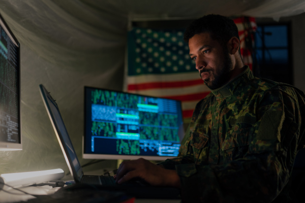 An American hacker in military unifrorm on dark web, cyberwar concept.