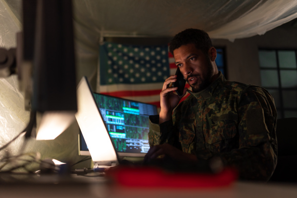 An American hacker in military unifrorm on dark web, cyberwar concept.