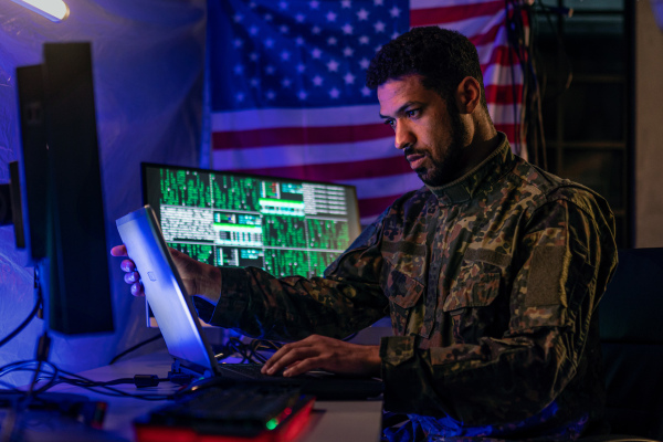 An American hacker in military unifrorm on dark web, cyberwar concept.