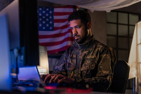 An American hacker in military unifrorm on dark web, cyberwar concept.