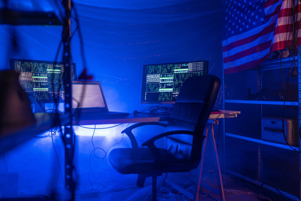 An internet hacker workplace in dark office, cyberwar concept.