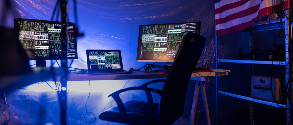 An internet hacker workplace in dark office, cyberwar concept.