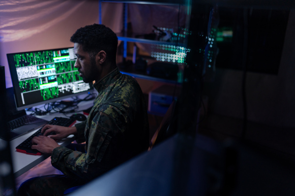 A hacker in military unifrorm on dark web, cyberwar concept.