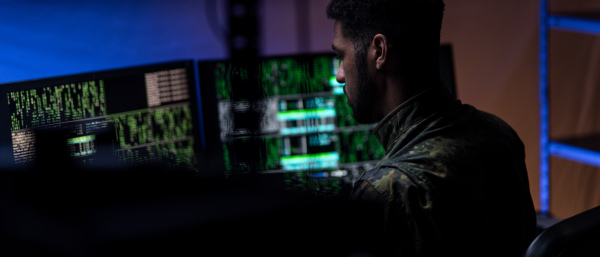 A hacker in military unifrorm on dark web, cyberwar concept.