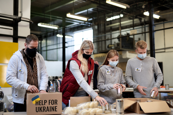 Volunteers sorting out donated food for the needs of the Ukrainian migrants, humanitarian aid concept.