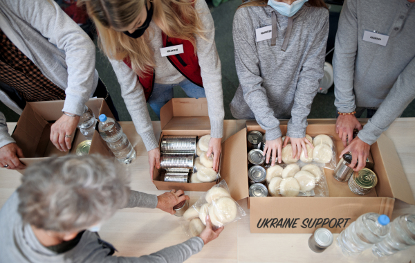 Top view of group of volunteers collect donations for the Ukrainian refugees, humanitarian aid concept.