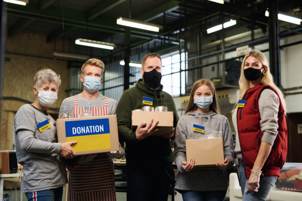 Group of volunteers helping in the Ukrainian refugee centre looking at camera, Russian conflict concept.