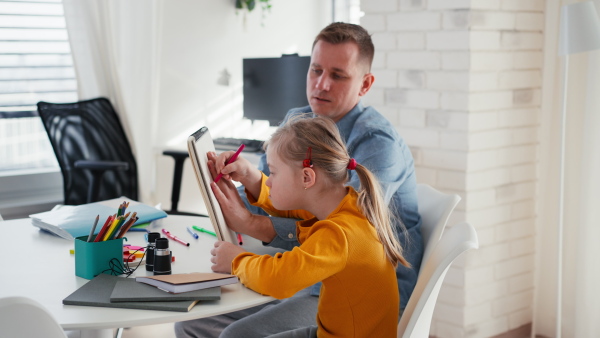 A father with his little daughter with Down syndrome learning at home.