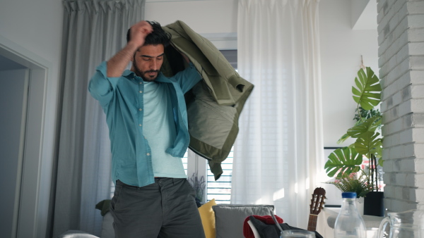 Young man hurrying up to work, taking his stuff.