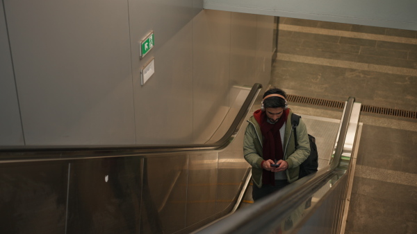 Young man moving on at escalator in a subway. Eco transport and commuting concept.