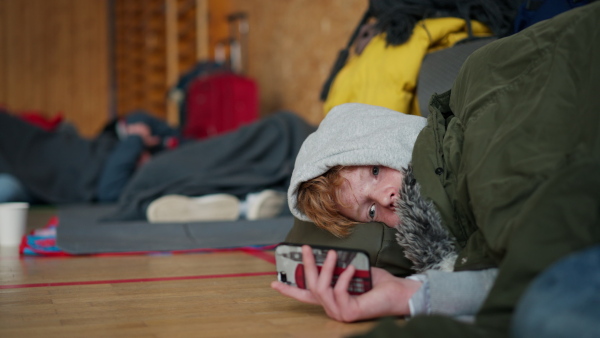 An Ukrainian teenage boy war refugee in temporary shelter and help center.