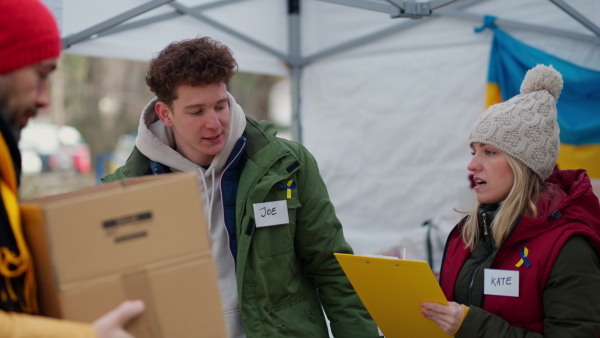 The volunteers distributing food and blankets on the Ukrainian border, humanitarian aid concept.