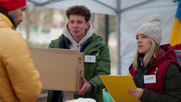 The volunteers distributing food and blankets on the Ukrainian border, humanitarian aid concept.