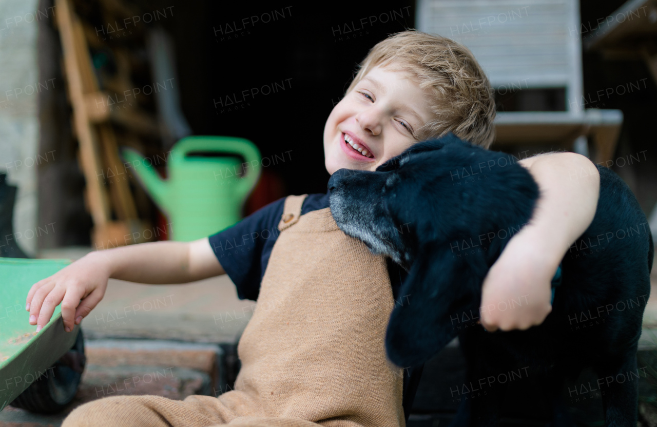 Portrait of little boy with his dog in the garden.