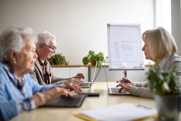 A senior group in retirement home learning together in computer class