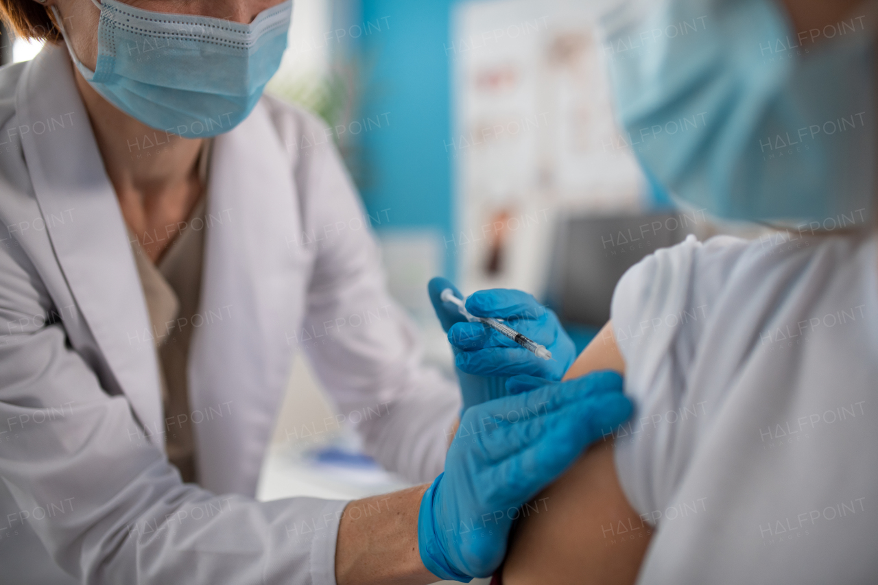 A close-up of young man getting covid-19 vaccince from his doctor in clinic.