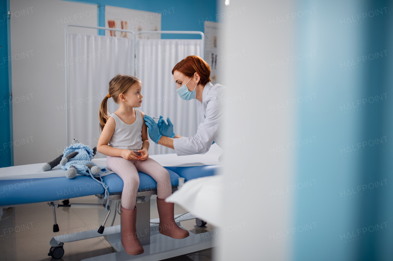 A worried little girl getting vaccinated in doctor's office.