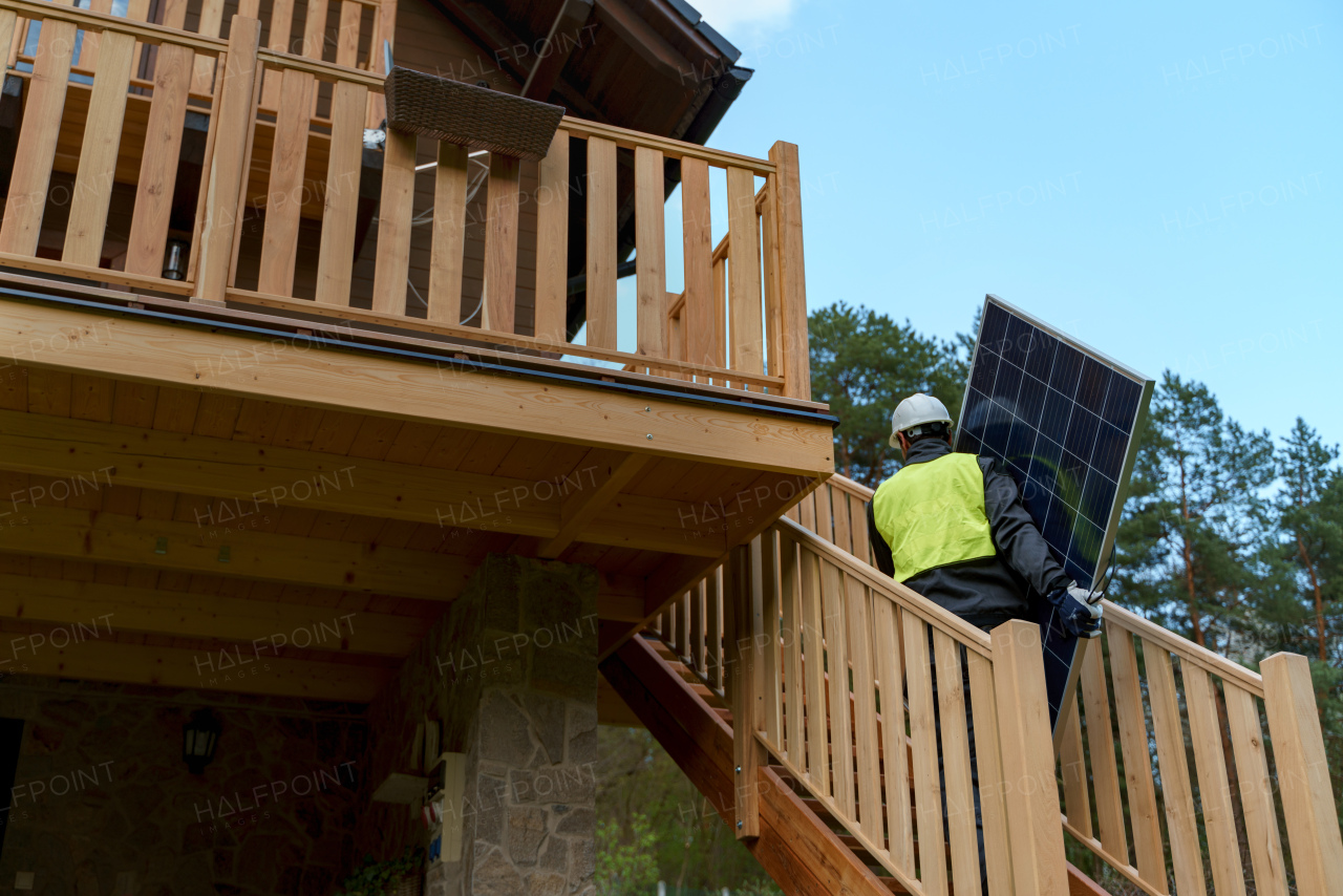 A man worker carrying solar panel for installing solar modul system on house.