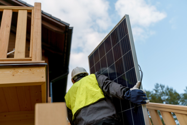 A man worker carrying solar panel for installing solar modul system on house.