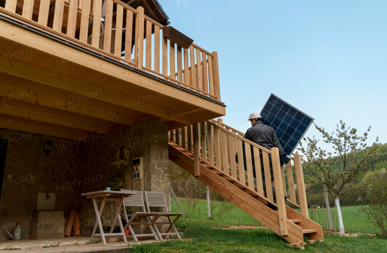 A man worker carrying solar panel for installing solar modul system on house.