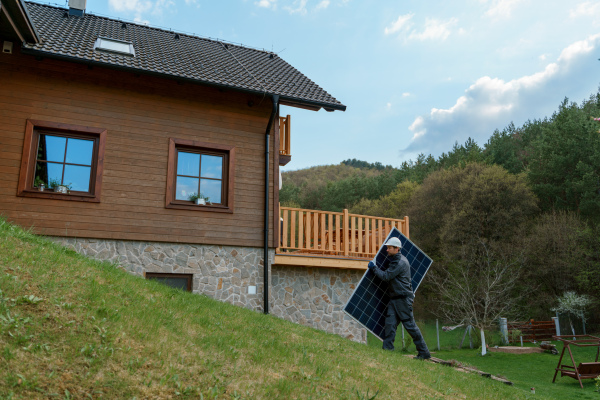 A man worker carrying solar panel for installing solar modul system on house.