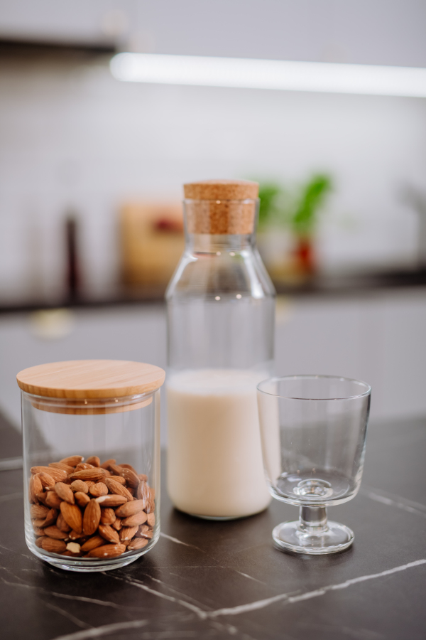 An almond milk and glass on kitchen counter. Healthy vegan product concept.