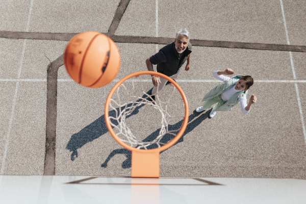 A happy father and teen daughter embracing and standing under a basketball hoop net, directly above