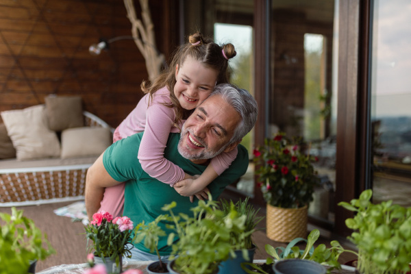 A portrait of little cute daughter hugging her happy father at home.