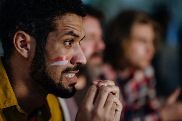 Nervous football fans friends watching a German national team in live soccer match on TV at home