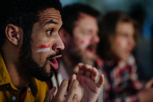 Nervous football fans friends watching a German national team in live soccer match on TV at home