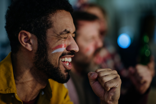 Nervous football fans friends watching a German national team in live soccer match on TV at home