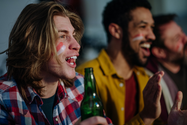 Happy Austrian football fans friends watching football at home and celebrating success