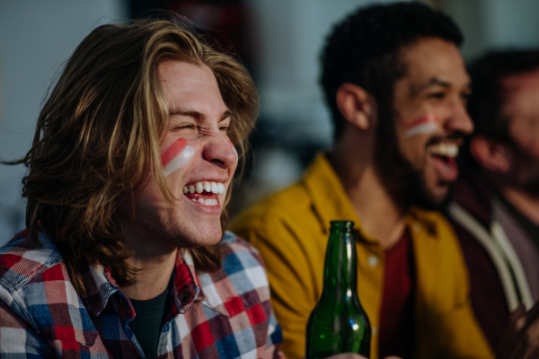 Happy Austrian football fans friends watching football at home and celebrating success