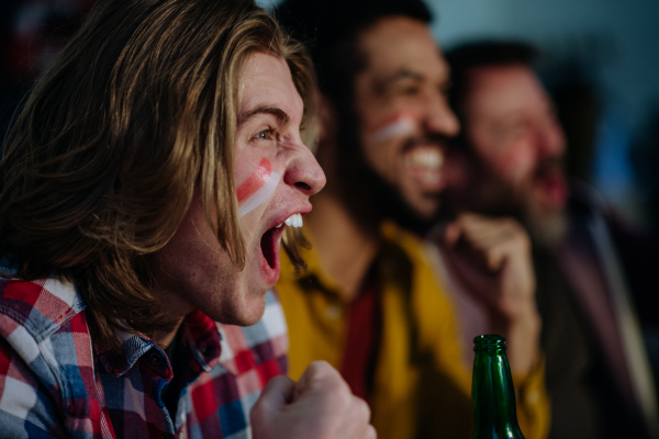 Happy Austrian football fans friends watching football at home and celebrating success