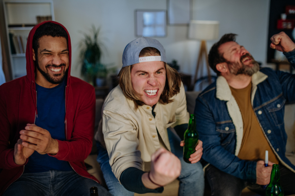 Happy football fans friends watching football at home and celebrating success