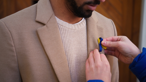 A protest organizer distributing Ukrainian blue and yellow ribbons to people protesting against war in Ukraine