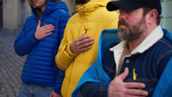 Protestors with Ukrainian blue and yellow ribbons and flags protesting against a war in Ukraine in street