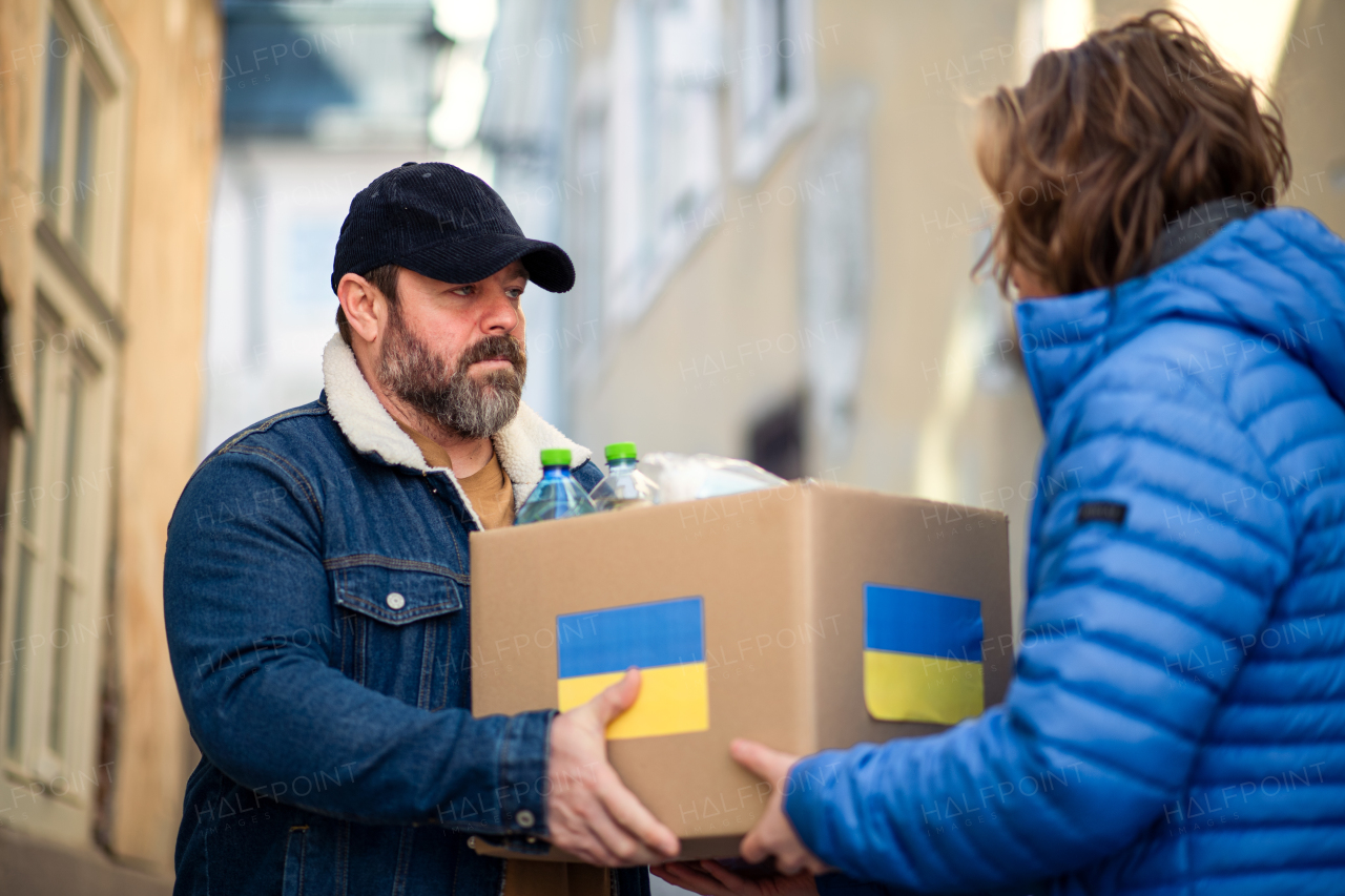 Volunteers collecting boxes with Humanitarian aid for the Ukrainian immigrants in street.