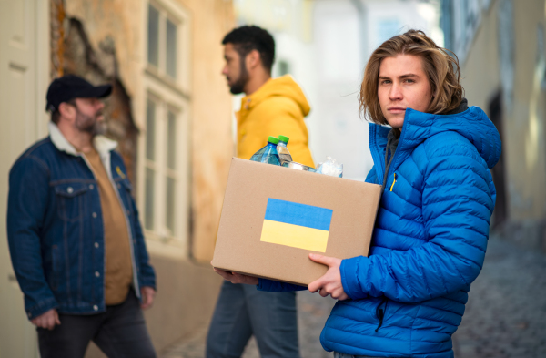 The team of volunteers collecting boxes with Humanitarian aid for Ukrainian refugees in street