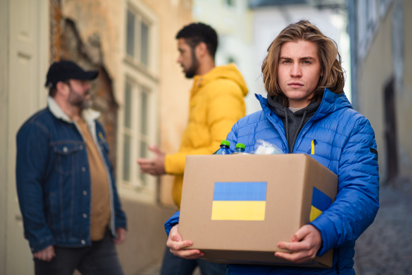 The team of volunteers collecting boxes with Humanitarian aid for Ukrainian refugees in street