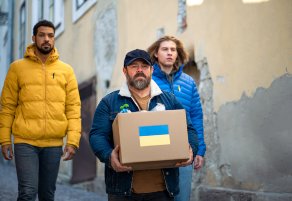 The team of volunteers collecting boxes with Humanitarian aid for Ukrainian refugees in street