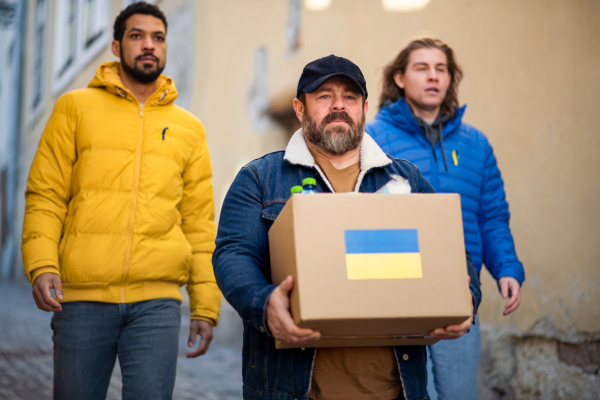 The team of volunteers collecting boxes with Humanitarian aid for Ukrainian refugees in street