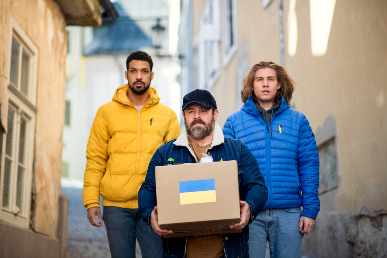 The team of volunteers collecting boxes with Humanitarian aid for Ukrainian refugees in street