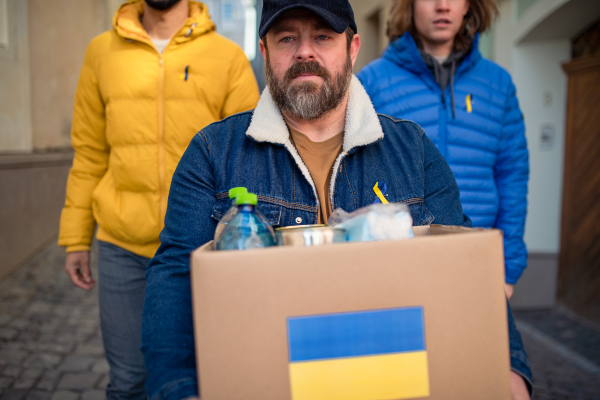 The team of volunteers collecting boxes with Humanitarian aid for Ukrainian refugees in street